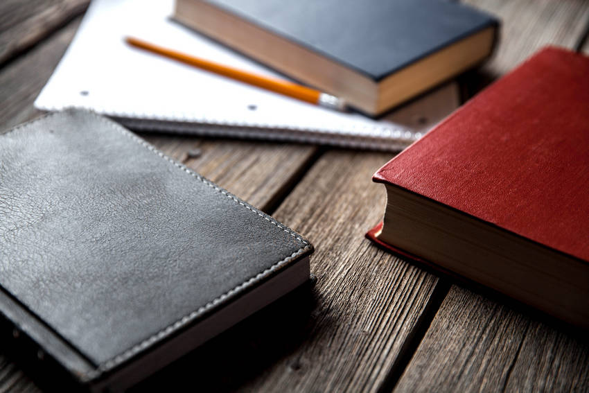 Business concept, ideas, books and exercise book on a wooden background with pencils