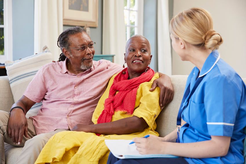 Female Community Nurse Visits Senior Couple At Home