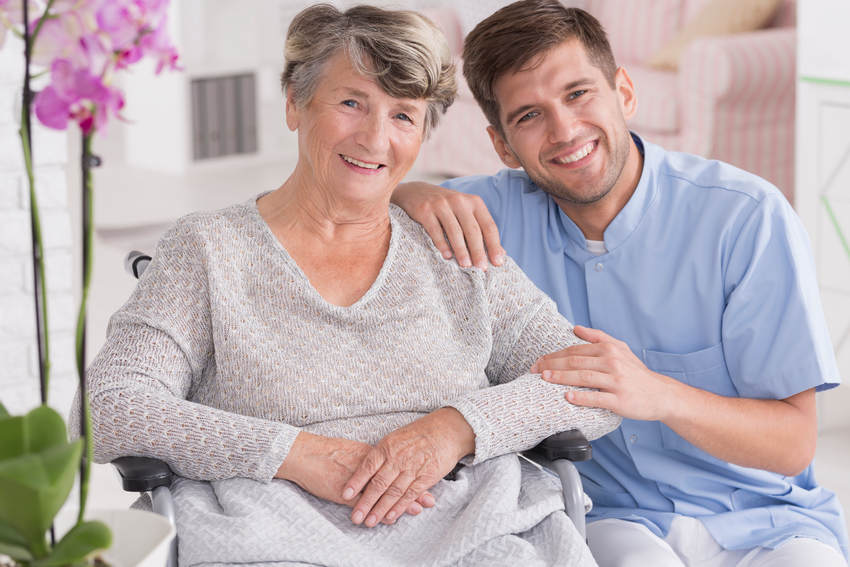 Smiling carer with senior in rest home