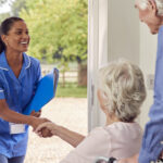 Senior Couple With Woman In Wheelchair Greeting Nurse Or Care Worker Making Home Visit At Door What Are Personal Care Homes