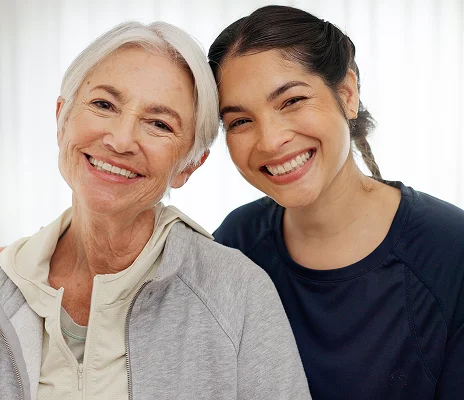 Senior woman and caregiver smiling together