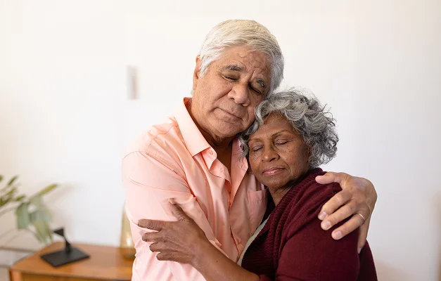 Elderly couple embracing at home