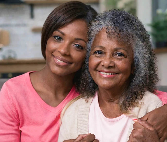 Smiling woman embracing elderly mother in warm family portrait