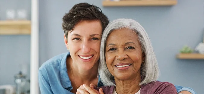 Caregiver and senior woman smiling together during personalized elderly home care support