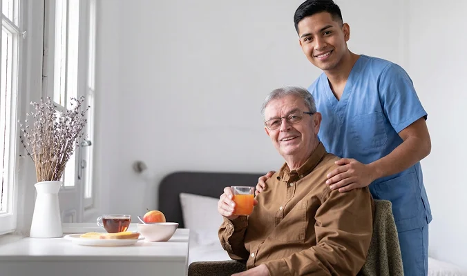 Professional home caregiver assisting senior man during in-home care visit
