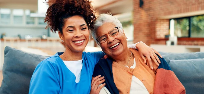 Smiling caregiver and elderly woman enjoying companionship and personalized senior care