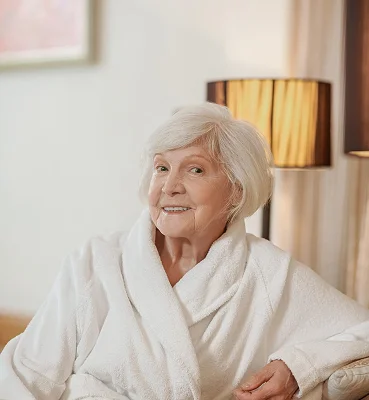 Happy senior woman relaxing comfortably at home with personal care support