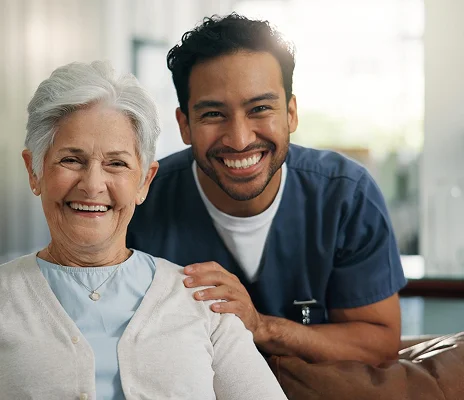 Male caregiver and senior woman smiling during compassionate elderly care visit