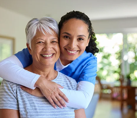 Compassionate caregiver hugging senior woman during personalized in-home care visit