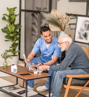 Male caregiver helping senior man with tablet and telehealth support services