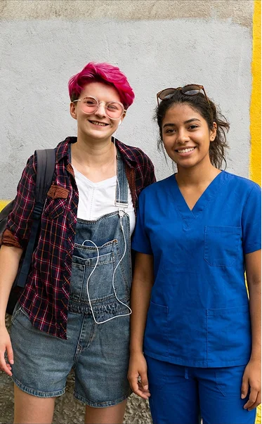 Caregiver standing with young adult during inclusive disability support and community care
