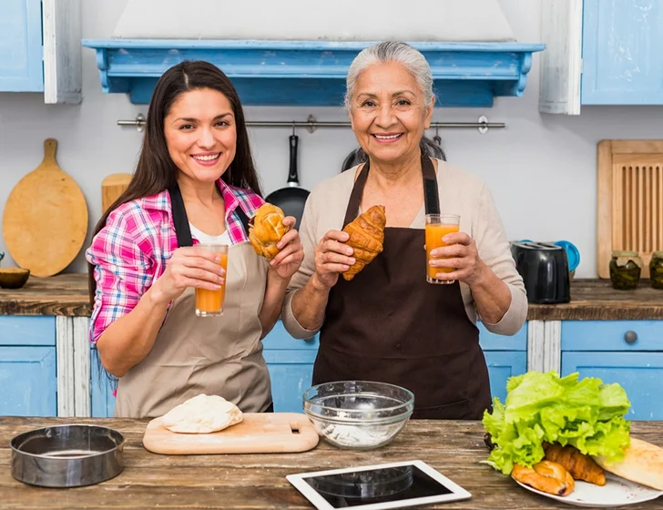 Caregiver and senior woman enjoying breakfast together in a cozy home kitchen
