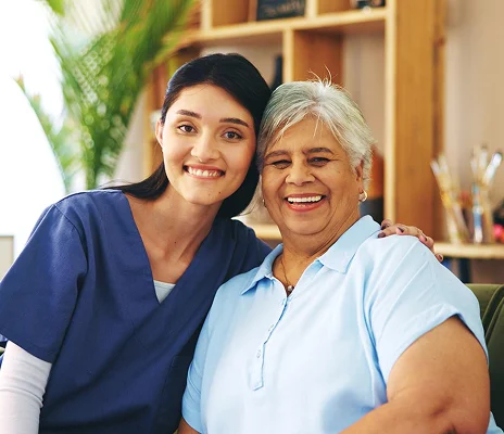 Caregiver and senior woman smiling together at home
